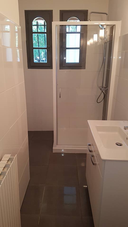Salle de bains après rénovation, avec douche vitrée et meuble vasque